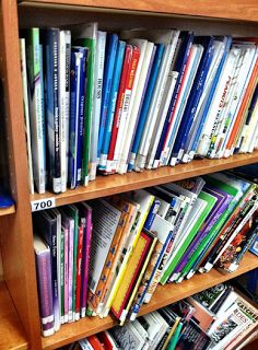 a bookshelf filled with lots of books on top of wooden shelves