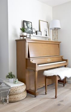 a living room with a piano and ottoman