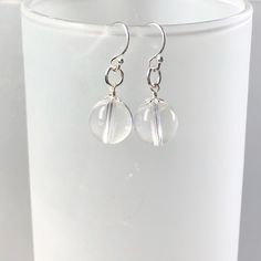 A beautiful pair of Clear Quartz Earrings. These earrings are made with 925 sterling silver with gorgeous AAA 10 mm clear quartz gemstones. Please note, the bead caps maybe slightly different as they are randomly picked. Clear Quartz - Master Healing Stone * Said to heal issues at the physical, mental, emotional or soul level * Helps to amply the energy of other gemstones * Meditation gemstone * Healing stone for all chakras Sizing : The clear quartz gemstones each measures about 10mm. Each pair Gift Crystal Earrings With Clear Ear Wire, Clear Round Crystal Earrings With Ear Wire, Clear Quartz Earring, Nickel-free Sterling Silver Clear Crystal Earrings, Silver Nickel-free Spiritual Crystal Earrings, Malachite Earrings, Small Pendant, Quartz Earrings, Gemstone Healing