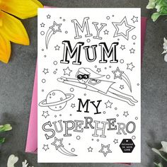 a card with the words, my mum is my superhero on it next to flowers