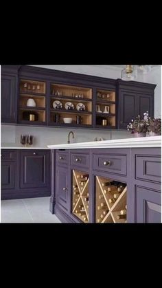 a wine rack in the middle of a kitchen with purple cabinets and white counter tops