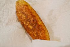 a piece of fried food sitting on top of a white paper towel next to a knife