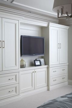 a flat screen tv sitting on top of a white cabinet