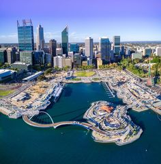 an aerial view of a city with lots of tall buildings and boats in the water