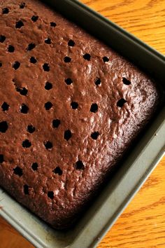 a chocolate cake in a pan on a wooden table