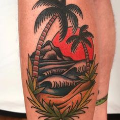 a man with a tattoo on his leg that has a palm tree and mountains in the background