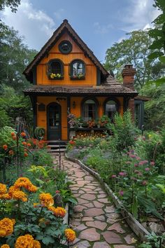 a yellow house surrounded by flowers and greenery