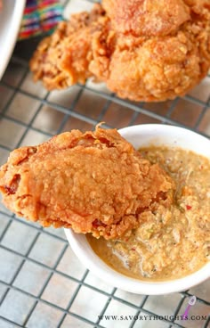 two fried chicken patties in a white bowl with dipping sauce on the side and another dish next to it