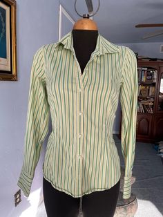 "Vintage mens' style shirt for woman, great fit spandex 3%, cotton 97% washable. please look at the princess cut style, very flattering! US Size M please check measurements below: SHOULDERS: 14.5\" BUST: 36\" WAIST: 29-31\" SLEEVES LENGHT: 23. 3/4\" LENGHT: 24\" FINAL SALE, NO RETURNS, NO EXCHANGES PLEASE CONTACT FOR ANY QUESTIONS OR CONCERNS." Vertical Striped Fitted Tops, Green Cotton Shirt With Striped Collar, Spring Green Shirt With Vertical Stripes, Green Long Sleeve Shirt With Striped Collar, Green Vertical Stripes Shirt For Spring, Fitted Long Sleeve Shirt With Vertical Stripes, Fitted Shirt With Striped Collar For Spring, Green Slim Fit Cotton Tops, Green Stretch Long Sleeve Shirt