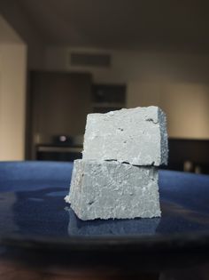 two blocks of white soap sitting on top of a blue plate in a living room