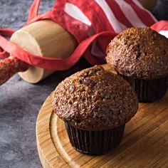 two muffins sitting on top of a wooden plate next to an american flag