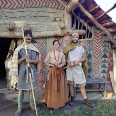 three people standing in front of a building with native art on the walls and floor