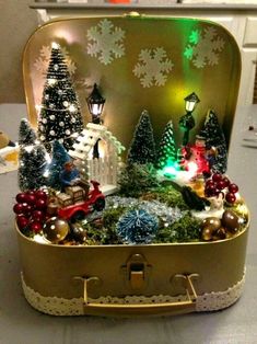 an open suitcase filled with christmas decorations on top of a table next to a lamp