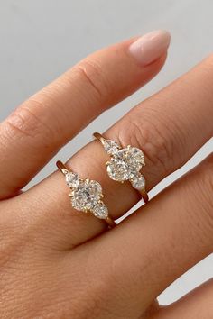 a woman's hand with two gold rings on it and one diamond ring in the middle