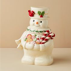 a ceramic snowman with candy canes and candies