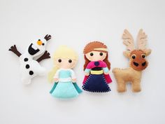 three felt dolls are lined up next to each other on a white surface with snowman, frozen princess and reindeer