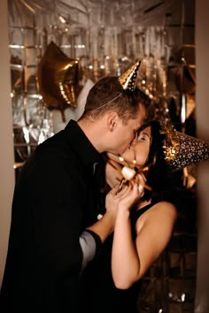 a man and woman kissing each other in front of gold decorations on the wall behind them