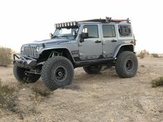 a gray jeep is parked in the desert