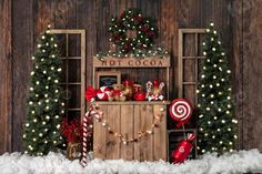 a christmas display with candy canes, candies and other holiday decorations in front of a wooden wall