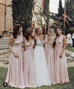 the bridesmaids are all dressed in pink dresses and one is wearing a white dress