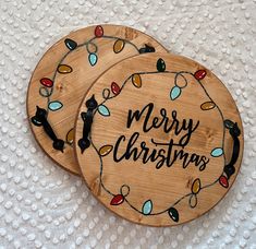 two wooden coasters decorated with christmas lights and the words merry christmas written on them