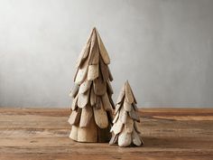 two wooden christmas trees sitting on top of a wooden table