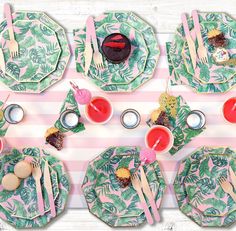 the table is set with pink and green plates