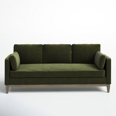 a green couch sitting on top of a white floor