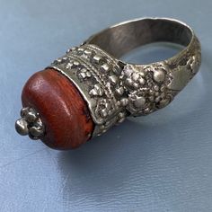 Antique ~ Very well Handmade ~ old Yemeni silver ring ~ Featuring a large central amber or amber resin set on an closed back bezel setting with wire and beaded border ~ Unsigned but acid tested for atleast 800 silver . Dates first half or 20th century Measurements : Ring can fit size 8 - 8 1/2 . Front is 1/2 inches in max diameter x 5/8inches in height Weighs 9 grams on my weighing scale . Condition : Good old condition ,with heavy age patina to silver and central bead ~ No cracks /chips to cora Middle East Jewelry, Amber Resin, Weighing Scale, Resin Ring, Silver Work, Metal Work, Silver Pendant Necklace, Bezel Setting, Middle East