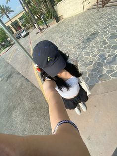 a woman is holding onto a pole with her hat on and pointing at the camera