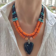 Make a bold statement with this handmade black agate pendant necklace, featuring stunning black onyx and orange mother of pearl beads, and turquoise gemstones. The unique combination of these materials creates a stunning contrast that's sure to catch the eye. The necklace is designed for women and makes a perfect gift for someone special or a stylish addition to your own collection. The pendant's intricate design and elegant black finish add a touch of sophistication, while the bold orange and t Pearl Beads Necklace, Hematite Jewelry, Natural Gemstone Necklace, Tiger Eye Jewelry, Mother Of Pearl Jewelry, Agate Pendant Necklace, Hippie Necklace, Necklace Turquoise, Agate Jewelry