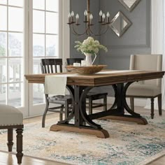 a dining room table with chairs and a rug on the floor in front of it