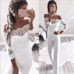 a woman taking a selfie in her white dress and leggings, while holding a cell phone