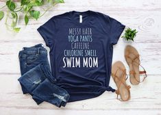 "Show your swim mom pride with our ultra-comfortable and stylish t-shirt. Perfect for mothers who tirelessly support their kids' swimming passion, this shirt is a must-have in every swim parent's wardrobe. Our Swim Mom t-shirt is not just a style statement; it is designed for ultimate comfort. Its soft and lightweight fabric, combined with the right amount of stretch, ensures a flattering fit for all. Whether you're on the bleachers cheering for your child or running errands, this shirt is guara Swim Mom Shirt, Swimming Team, Mom Pride, The Bleachers, Swim Mom, Gifts For Swimmers, Swim Season, Swim Shirts, Bleachers