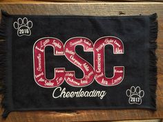 a black scarf with the words csc on it and a paw print in red