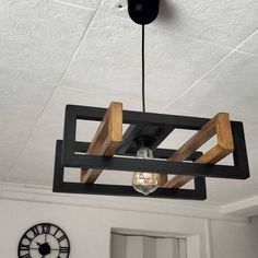 the light fixture is made out of wood and has a glass bulb hanging from it