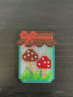 a cross stitch picture of two mushrooms in a jar