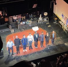 a group of men standing on top of a stage next to each other in front of an audience