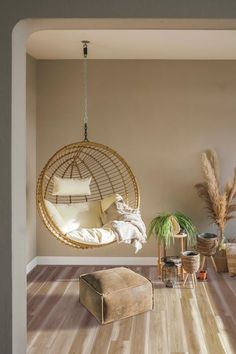 a living room with wood flooring and a hanging chair in the middle of it