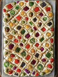 a square shaped pizza with many different toppings on it