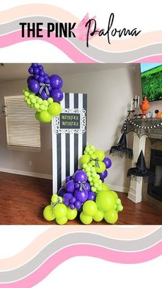 the pink panda balloon stand is decorated with purple and green balloons in front of a fireplace