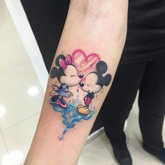 mickey and minnie mouse tattoo on the left inner arm with watercolor paint splashes