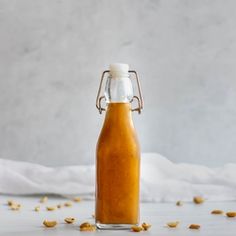 a bottle filled with peanut butter sitting on top of a white tablecloth covered floor