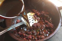 the sauce is being poured into the skillet to make it easier for the meat to be cooked