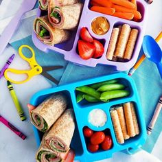 two plastic trays filled with sandwiches and veggies