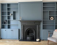 a living room with blue bookcases and a fire place in the middle of it