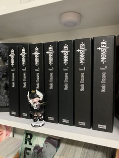 several black books on a white shelf in a room