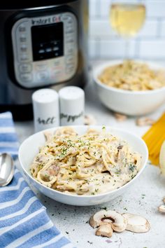 a bowl filled with pasta and mushrooms next to an instant pot