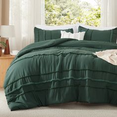 a green comforter set with white pillows