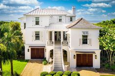 an aerial view of a large white house with two stories and three car garages